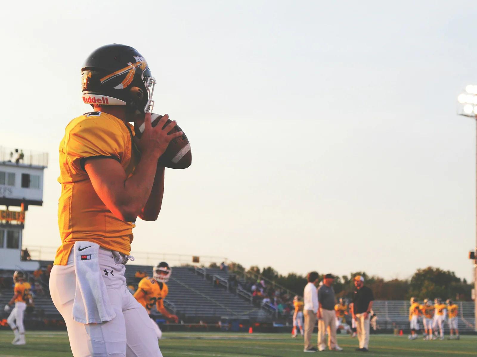 Quarterback preparing to pass during a late-afternoon football game